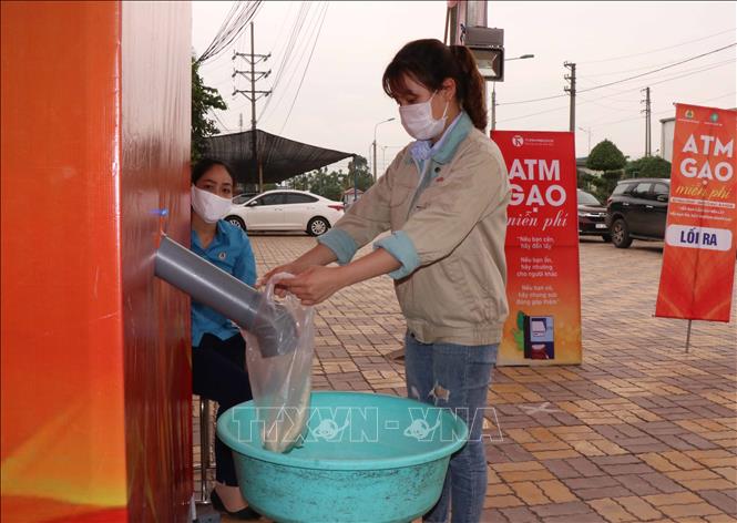 Trong ảnh: Công nhân lấy gạo miễn phí tại cây ATM gạo tại khu công nghiệp Quế Võ, tỉnh Bắc Ninh. Ảnh: Thái Hùng – TTXVN