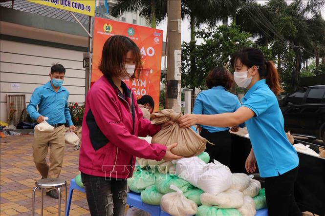 Trong ảnh: Công nhân nhận gạo miễn phí tại khu công nghiệp Quế Võ, tỉnh Bắc Ninh. Ảnh: Thái Hùng – TTXVN