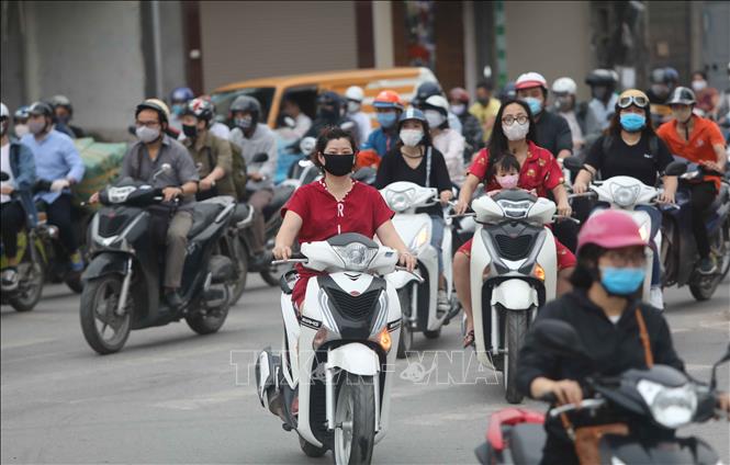 Trong ảnh: Cuối giờ chiều ngày 20/4, nhiều người dân Hà Nội ra đường không đội mũ bảo hiểm khi đi xe máy (ảnh chụp lúc 17h44p). Ảnh: Thanh Tùng - TTXVN