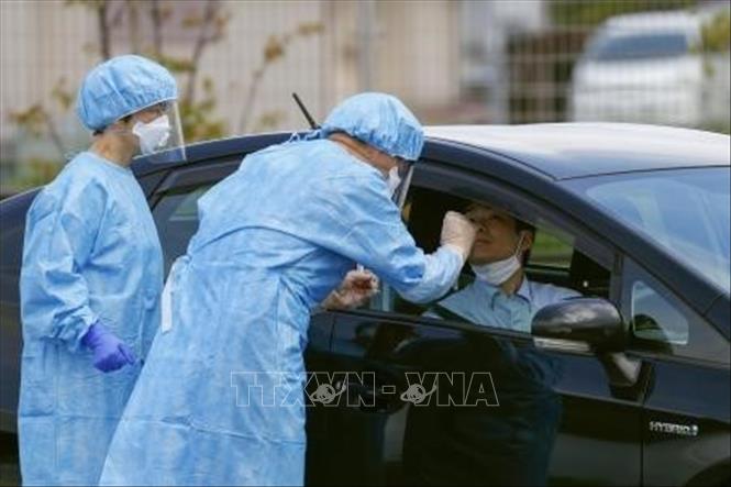 Trong ảnh: Nhân viên y tế lấy mẫu xét nghiệm COVID-19 tại Nara, miền Tây Nhật Bản. Ảnh: Kyodo/TTXVN