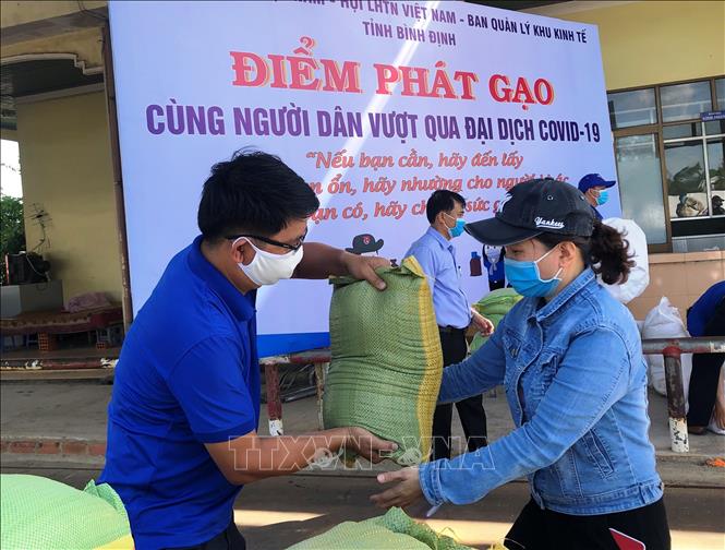 Trong ảnh: Công nhân Khu Công nghiệp Long Mỹ , TP Quy Nhơn nhận gạo từ chương trình. Ảnh: Nguyên Linh – TTXVN