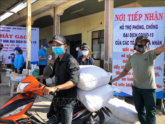 Trong ảnh: Công nhân tại Khu Công nghiệp Long Mỹ , TP Quy Nhơn, tỉnh Bình Định nhận gạo hỗ trợ của chương trình. Ảnh: Nguyên Linh – TTXVN