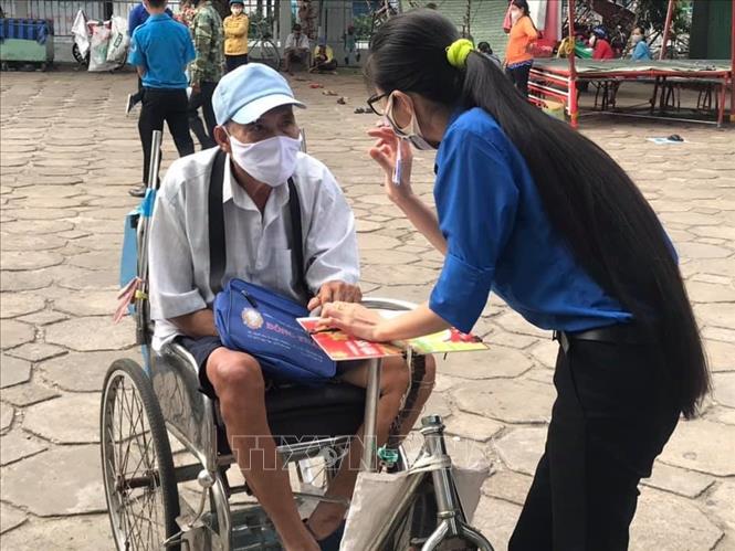 Trong ảnh: Các đoàn viên giúp đỡ những người đi lại khó khăn, cao tuổi đến ''Siêu thị 0 đồng''. Ảnh: Ánh Tuyết - TTXVN