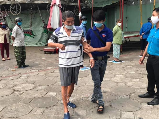 Trong ảnh: Các đoàn viên giúp đỡ những người đi lại khó khăn, cao tuổi...đến ''Siêu thị 0 đồng''. Ảnh: Ánh Tuyết - TTXVN