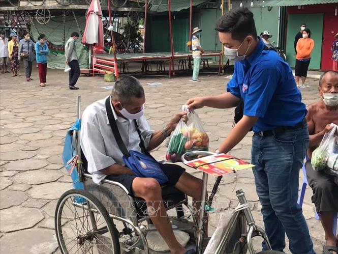Trong ảnh: Các đoàn viên giúp đỡ những người đi lại khó khăn, cao tuổi...tại ''Siêu thị 0 đồng''. Ảnh: Ánh Tuyết - TTXVN