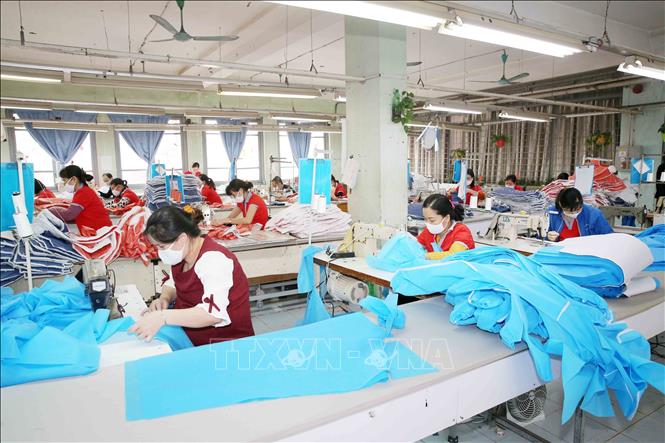 Photo: Producing medical suits and face masks at the Chien Thang Garment JSC in Hanoi. VNA Photo: Phương Hoa
