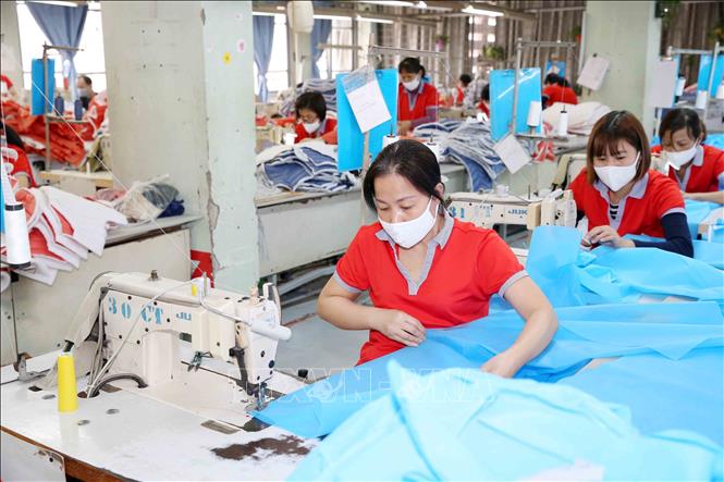 Photo: Producing medical suits and face masks at the Chien Thang Garment JSC in Hanoi. VNA Photo: Phương Hoa