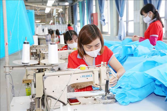 Photo: Producing medical suits and face masks at the Chien Thang Garment JSC in Hanoi. VNA Photo: Phương Hoa