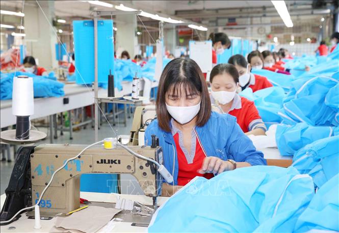 Photo: Producing medical suits and face masks at the Chien Thang Garment JSC in Hanoi. VNA Photo: Phương Hoa