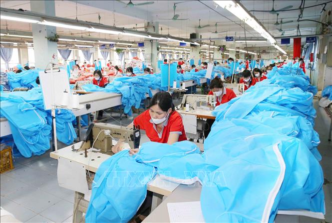 Photo: Producing medical suits and face masks at the Chien Thang Garment JSC in Hanoi. VNA Photo: Phương Hoa