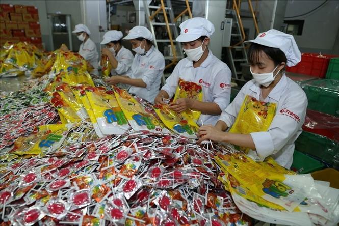 Trong ảnh: Công nhân Công ty Cổ phần Tràng An (Hà Nội) đóng gói sản phẩm kẹo.	 Ảnh: Vũ Sinh – TTXVN