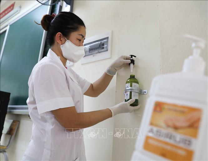 Trong ảnh: Nhân viên y tế Trường THCS Mạc Đĩnh Chi, quận Ba Đình kiểm tra các lọ nước sát khuẩn tay được bố trí trong mỗi phòng học. Ảnh: Thanh Tùng - TTXVN
