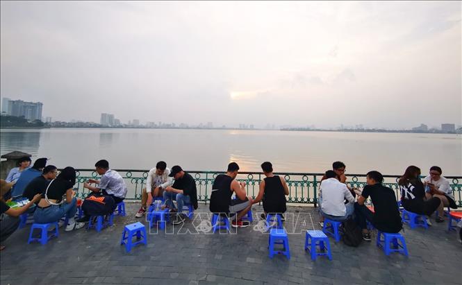 Trong ảnh: Tại khu vực Hồ Tây tụ tập đông người ngồi uống nước không đảm bảo giãn khoảng cách cần thiết. Ảnh: Thành Đạt - TTXVN