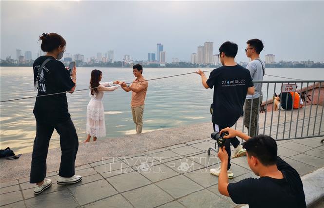 Trong ảnh: Nhiều người dân chủ quan không đeo khẩu trang tại khu vực Hồ Tây. Ảnh: Thành Đạt - TTXVN