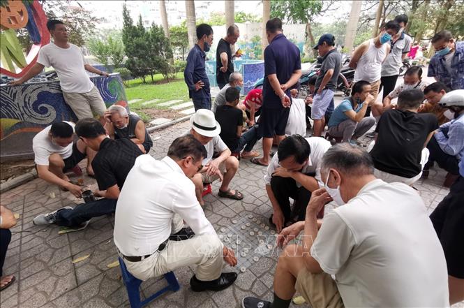 Trong ảnh: Tại các công viên người dân tụ tập đông người đánh cờ tiềm ẩn nguy cơ lây nhiễm dịch bệnh. Ảnh: Thành Đạt - TTXVN