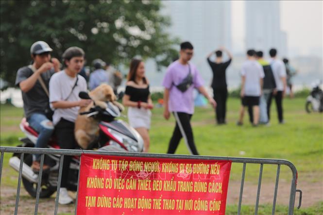 Trong ảnh: Dù đã có biển báo người dân vẫn chủ quan không đeo khẩu trang, tụ tập đông người tại khu vực Hồ Tây. Ảnh: Thành Đạt - TTXVN