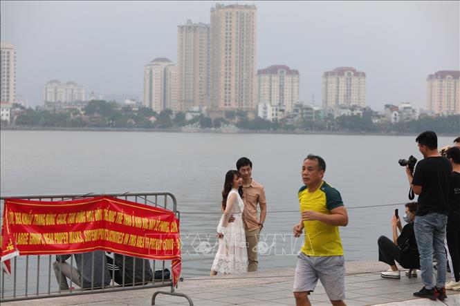 Trong ảnh: Nhiều người dân chủ quan không đeo khẩu trang, không tuân thủ quy định giãn cách tại khu vực ven Hồ Tây. Ảnh: Thành Đạt - TTXVN