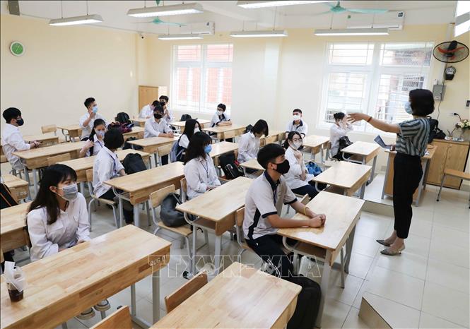Trong ảnh: Giáo viên hướng dẫn học sinh ngồi trong lớp theo vị trí đảm bảo giãn cách tối thiểu. Ảnh: Thanh Tùng - TTXVN