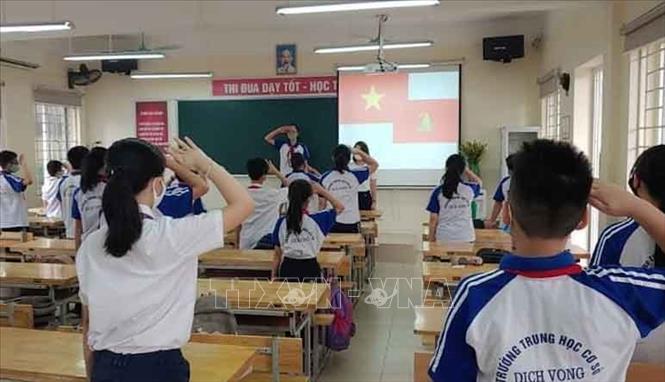 Trong ảnh: Học sinh trường THCS Dịch Vọng, quận Cầu Giấy chào cờ trong lớp học. Ảnh: Nguyễn Cúc - TTXVN