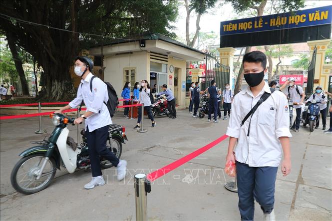Trong ảnh: Các em học sinh Trường THPT Việt Đức đảm bảo giãn cách cần thiết khi vào trường. Ảnh: Thành Đạt - TTXVN
