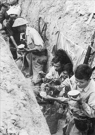 Trong ảnh: Bộ đội ta ăn cơm dưới chiến hào trong chiến dịch Điện Biên Phủ 1954. Ảnh: Tư liệu/TTXVN phát