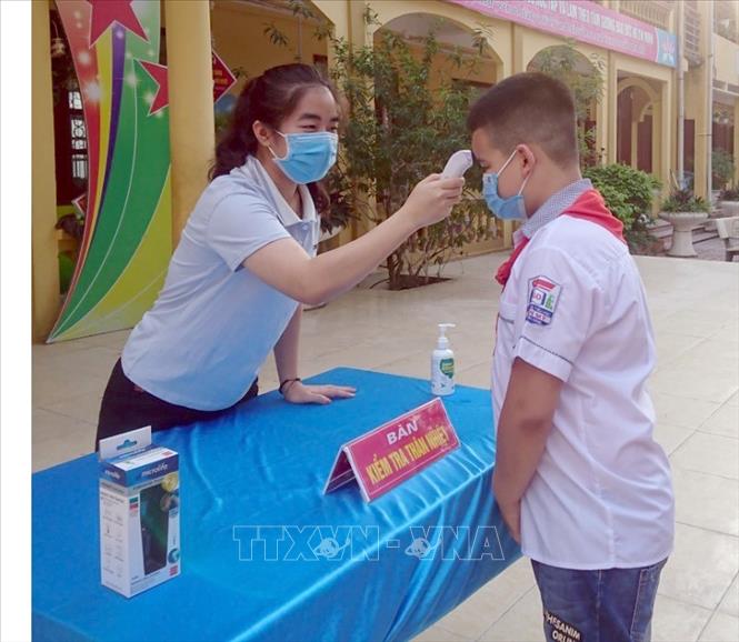 Trong ảnh: Học sinh trường tiểu học Tân Mỹ, TP Bắc Giang được đo thân nhiệt trước khi vào lớp. Ảnh: Đồng Thúy-TTXVN