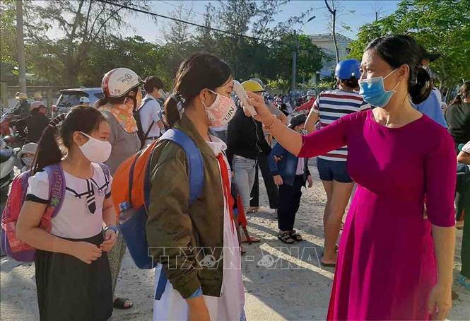 Trong ảnh: Giáo viên trường Tiểu học Lạc Long Quân (thành phố Tuy Hòa-Phú Yên) đo thân nhiệt cho học sinh trước khi vờ lớp. Ảnh: Xuân Triệu - TTXVN