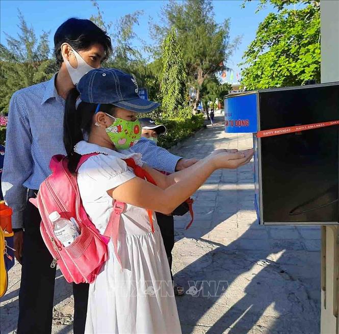 Trong ảnh: Giáo viên trường Tiểu học Lạc Long Quân (thành phố Tuy Hòa-Phú Yên) rửa tay khử khuẩn trước khi vờ lớp. Ảnh: Xuân Triệu - TTXVN