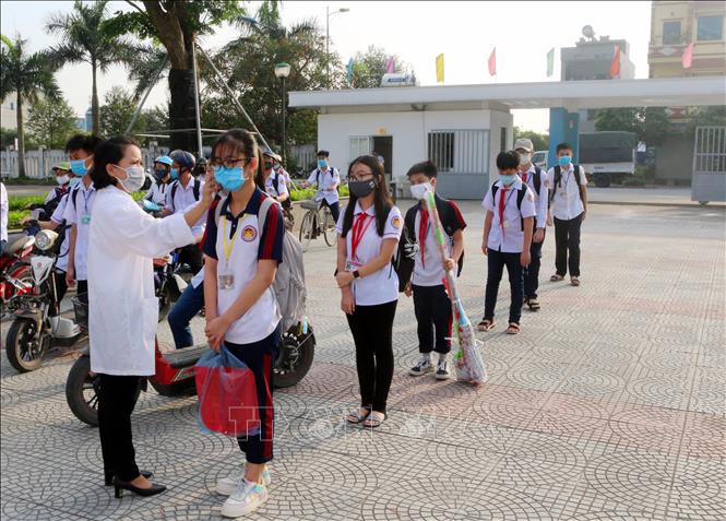 Trong ảnh: Học sinh trường chuyên Biên Hòa (thành phố Phủ Lý, tỉnh Hà Nam) được kiểm tra thân nhiệt trước khi vào lớp. Ảnh: Đại Nghĩa- TTXVN