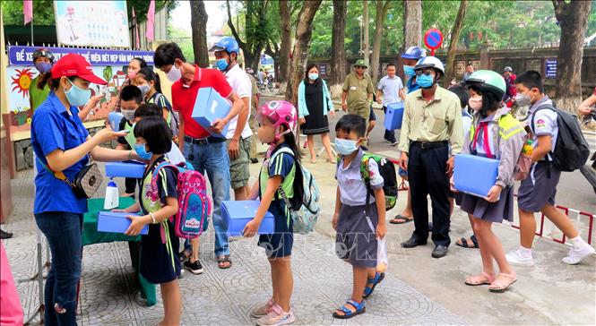 Trong ảnh: Trường Tiểu học Vĩnh Ninh, thành phố Huế tiến hành kiểm tra thân nhiệt cho học sinh trước khi vào lớp. Ảnh: Tường Vi - TTXVN