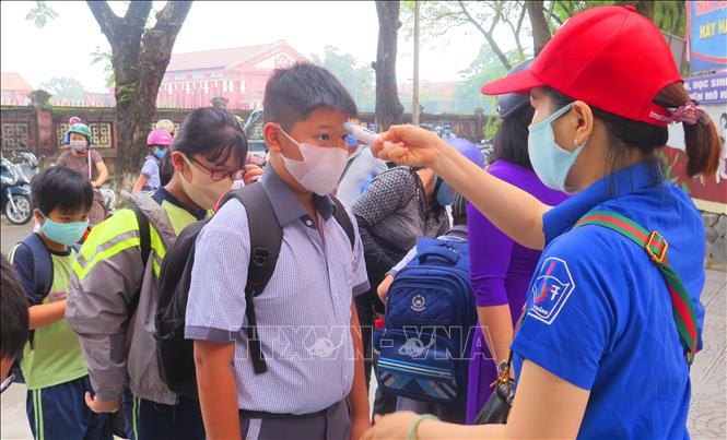 Trong ảnh: Trường Tiểu học Vĩnh Ninh, thành phố Huế tiến hành kiểm tra thân nhiệt cho học sinh trước khi vào lớp. Ảnh: Tường Vi - TTXVN