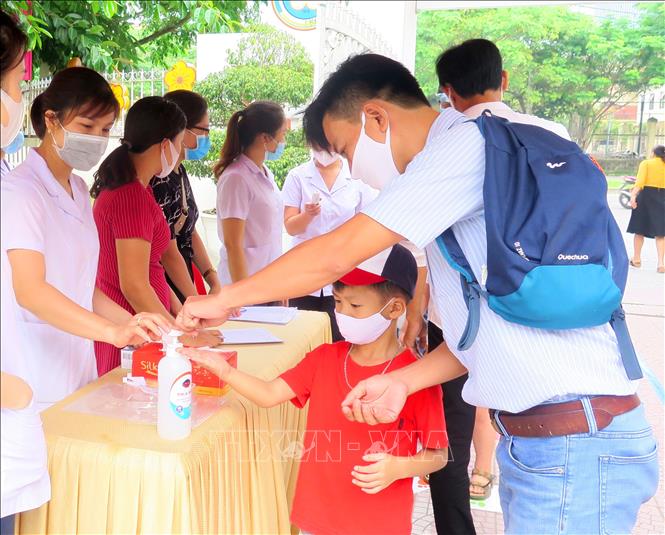 Trong ảnh: Giáo viên Trường Mầm non Hoa Mai hướng dẫn các cháu sát khuẩn tay trước khi vào lớp. Ảnh: Tường Vi - TTXVN