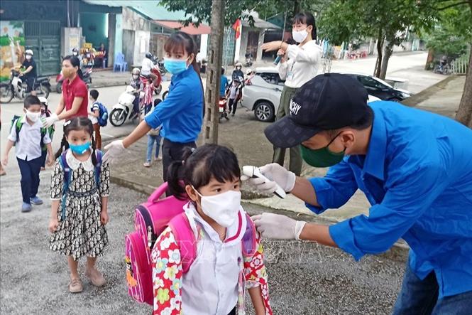 Trong ảnh: Ngày đầu tiên học sinh, sinh viên Quảng Ninh đi học trở lại được kiểm tra thân nhiệt trước khi vào lớp. Ảnh: TTXVN phát
