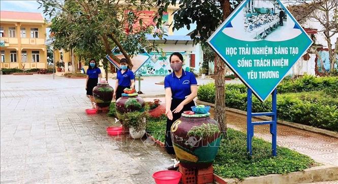 Trong ảnh: Giáo viên trường Tiểu học số 2 Quảng Văn (thị xã Ba Đồn, Quảng Bình) sáng tạo các bồn rửa tay xinh xắn, sạch đẹp từ việc tái chế các chum, vại đã qua sử dụng. Ảnh: Võ Dung -TTXVN