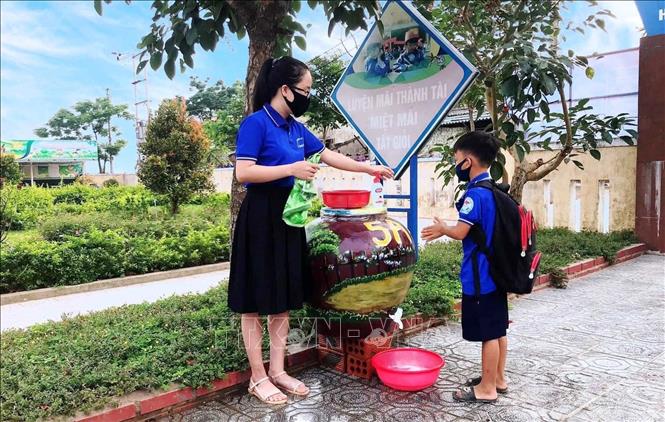 Trong ảnh: Giáo viên trường Tiểu học số 2 Quảng Văn (thị xã Ba Đồn, Quảng Bình) hướng dẫn học sinh cách rửa tay, sát khuẩn trước khi vào lớp. Ảnh: Võ Dung -TTXVN