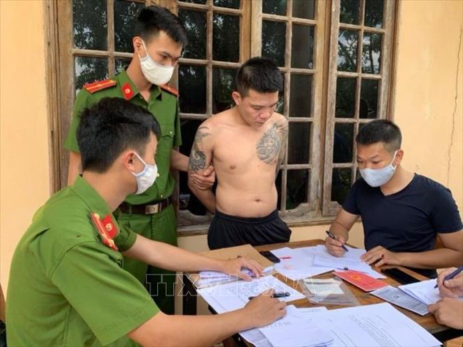 Trong ảnh: Đối tượng Trần Duy Khánh cùng tang vật liên quan. Ảnh: TTXVN phát