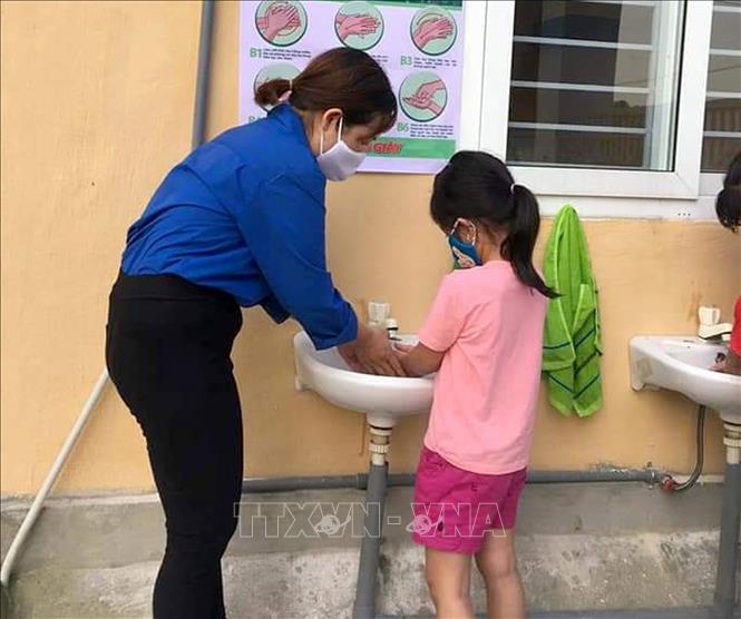Trong ảnh: Hướng dẫn học sinh rửa tay sát khuẩn trước khi vào lớp tại trường học ở huyện miền núi Như Thanh, tỉnh Thanh Hóa. Ảnh: Nguyễn Nam-TTXVN