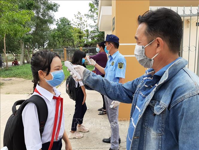 Trong ảnh: Đa số các trường học tại Long An trang bị máy đo và thực hiện kiểm tra thân nhiệt học sinh. Ảnh: Đức Hạnh - TTXVN