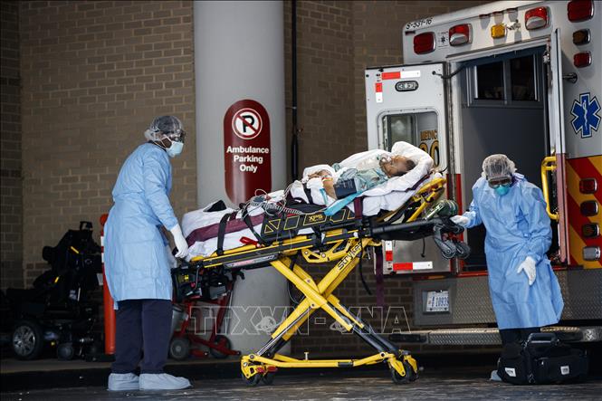 Trong ảnh: Nhân viên y tế chuyển bệnh nhân nhiễm COVID-19 tới bệnh viện ở Washington D.C., Mỹ. Ảnh: THX/TTXVN