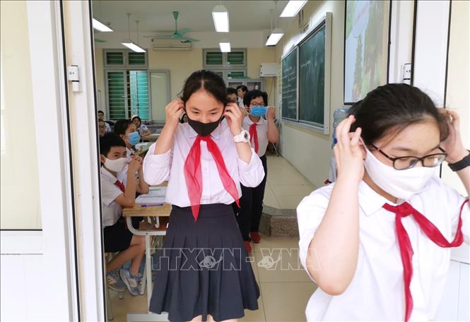 Trong ảnh: Học sinh trường THCS Trưng Vương thực hiện đeo khẩu trang khi hết tiết học ra khỏi lớp. Ảnh: Thành Đạt - TTXVN
