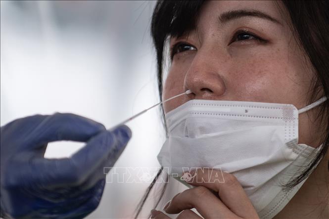 Trong ảnh: Nhân viên y tế lấy mẫu xét nghiệm PCR nhằm phát hiện người nhiễm COVID-19 tại Fujisawa, quận Kanagawa, Nhật Bản ngày 27/4/2020. Ảnh: AFP/TTXVN 