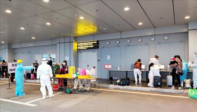 Trong ảnh: Lực lượng y tế hướng dẫn hành khách làm thủ tục. Ảnh: TTXVN phát
