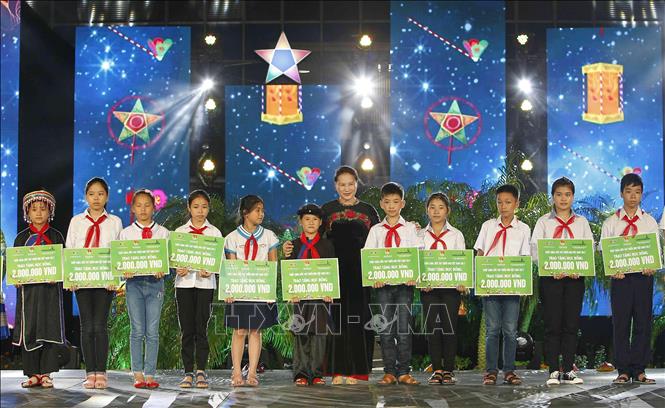 Trong ảnh: Chủ tịch Quốc hội Nguyễn Thị Kim Ngân trao quà cho các thiếu niên, nhi đồng có hoàn cảnh khó khăn, vượt khó vươn lên, tại chương trình “Lễ hội Mặt trăng - Thắp sáng ước mơ thiếu nhi Việt Nam”, ngày 1/10/2017. Ảnh: Văn Điệp –TTXVN