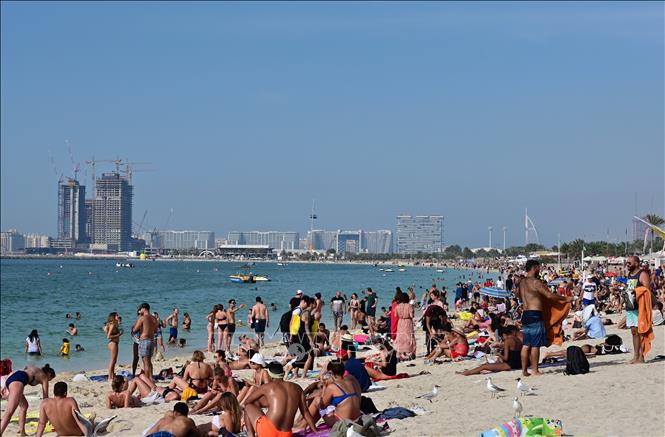 Trong ảnh: Người dân tắm nắng trên bãi biển ở Dubai, UAE, ngày 13/3/2020. Ảnh: AFP/TTXVN