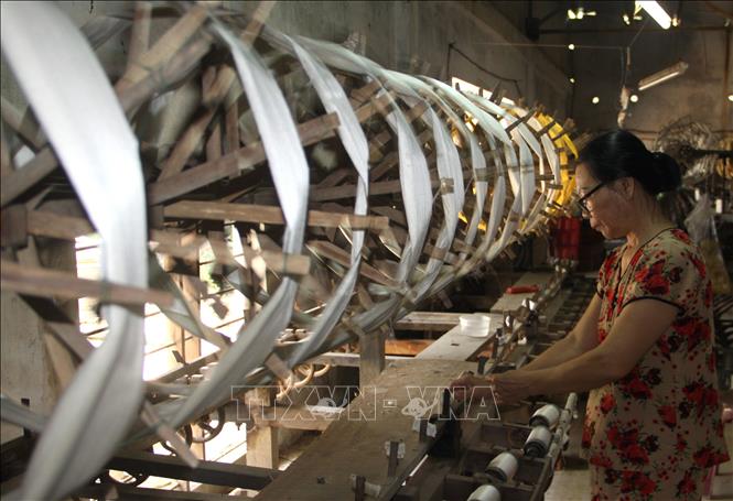 Trong ảnh: Công nhân Công ty TNHH tơ lụa Mã Châu ở thị trấn Nam Phước, huyện Duy Xuyên (tỉnh Quảng Nam) thực hiện một công đoạn trong quy trình sản xuất lụa. Ảnh: Trịnh Bang Nhiệm - TTXVN