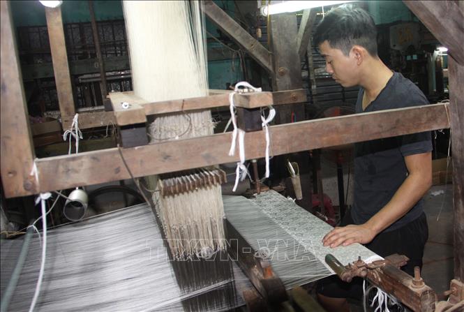 Trong ảnh: Công nhân Công ty TNHH tơ lụa Mã Châu ở thị trấn Nam Phước, huyện Duy Xuyên (tỉnh Quảng Nam)  đang thực hiện một công đoạn trong quy trình sản xuất lụa. Ảnh: Trịnh Bang Nhiệm - TTXVN