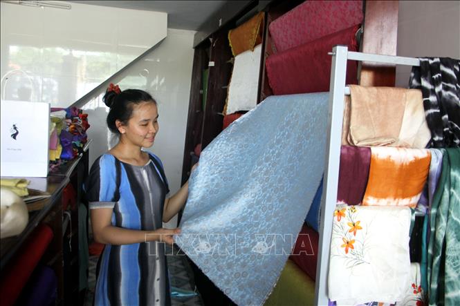 Trong ảnh: Du khách chọn mua lụa tơ tằm Mã Châu tại gian trưng bày thành phẩm của Công ty TNHH tơ lụa Mã Châu ở thị trấn Nam Phước, huyện Duy Xuyên (tỉnh Quảng Nam). Ảnh: Trịnh Bang Nhiệm - TTXVN