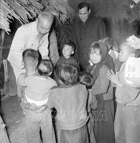 Trong ảnh: Bác Hồ đến thăm, ân cần hỏi chuyện con em gia đình có công với cách mạng ở thôn Phú Gia, xã Phú Thượng, Tây Hồ, Hà Nội (1955). Ảnh: TTXVN