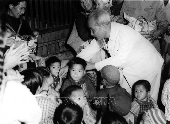 Trong ảnh: Bác Hồ thăm nhà trẻ, chia kẹo cho thiếu nhi là con cháu của công nhân Xí nghiệp gốm Dụ Phong và HTX Nông nghiệp Soáy Ngườn, thị xã Móng Cái (nay là TP Móng Cái, tỉnh Quảng Ninh). Ảnh: TTXVN