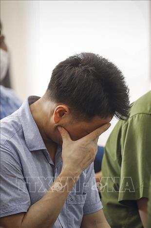 Trong ảnh: Bị cáo Nguyễn Khắc Tuấn liên tục che mặt tại phiên tòa ngày thứ 5 xét xử Vụ gian lận điểm tại Kỳ thi Trung học phổ thông Quốc gia năm 2018 tại Hòa Bình. Ảnh: Trọng Đạt - TTXVN